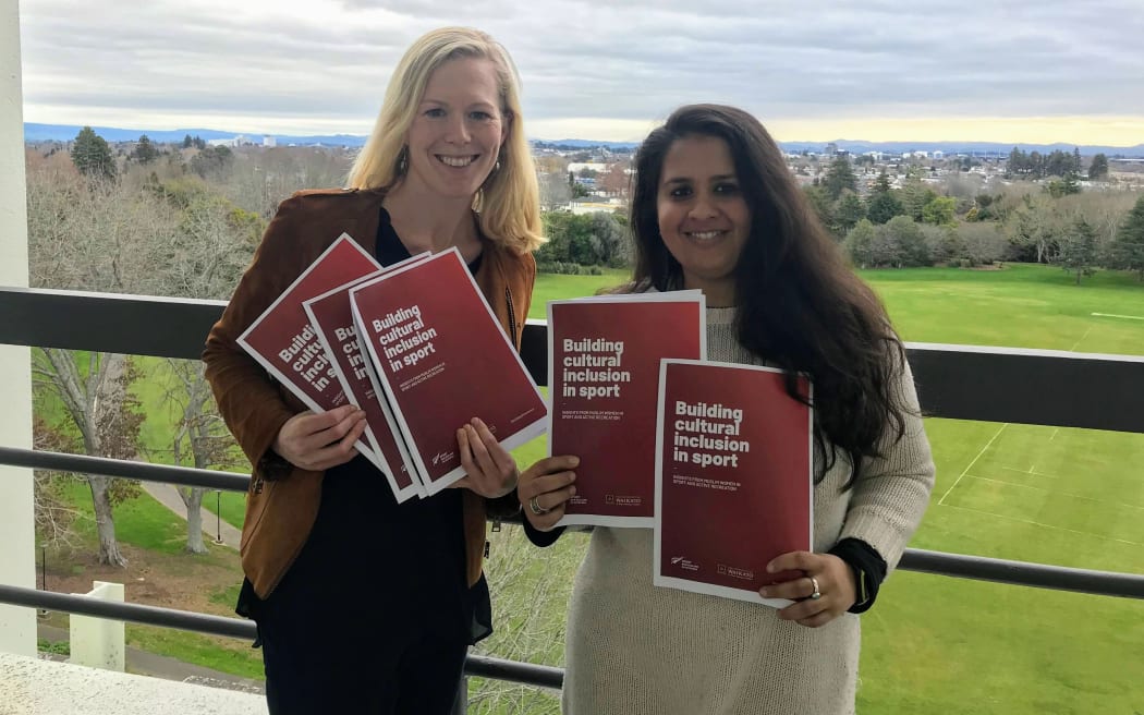 Professor Holly Thorpe and Dr Nida Ahmad with hard copies of their cultural inclusion report.