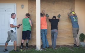 Workers help a friend board up his apartment building in Fort Pierce, Florida.