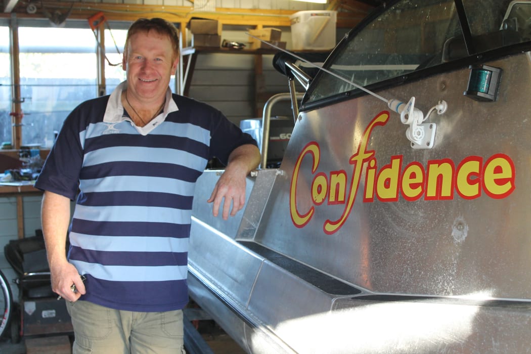 Kaikoura bach owner, Mark Boomer, with his fishing boat, Confidence.