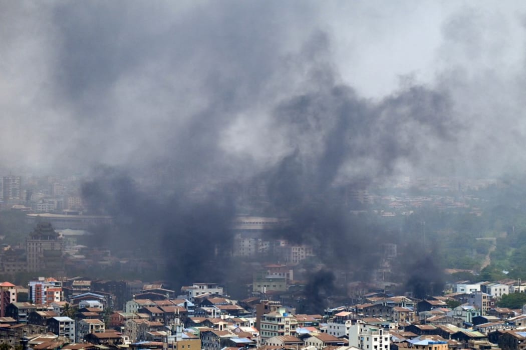 Smoke rises over Tamwe township in Yangon on March 27, 2021, as security forces continue their crackdown on protests against the military coup. (Photo by STR / AFP)