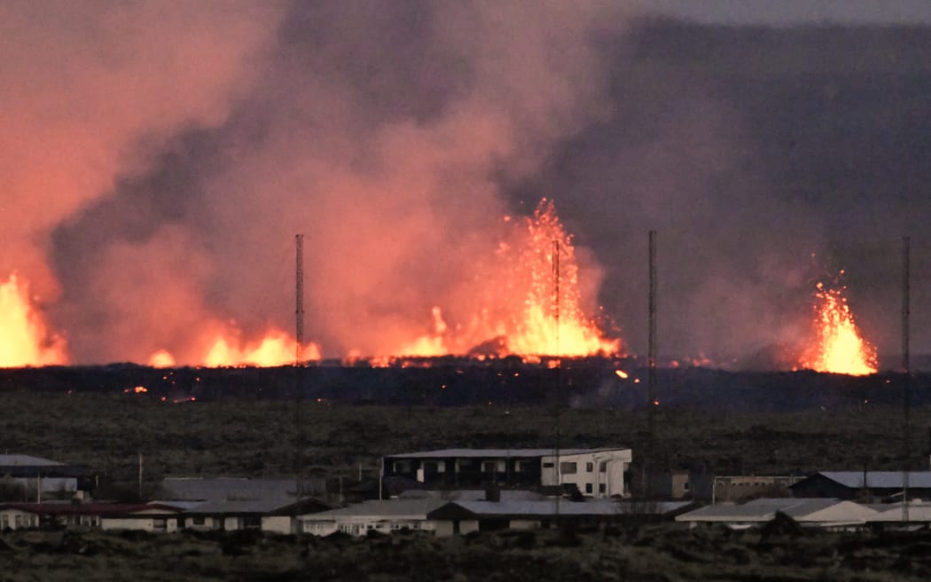 Lava explosions are seen near residential buildings in the southwestern Icelandic town of Grindavik after a volcanic eruption on January 14, 2024.