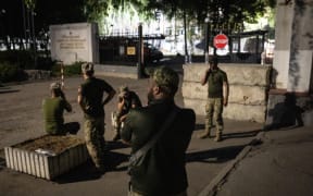 Ukrainian servicemen wait outside a military educational facility after it was hit by Russian missiles in Poltava, eastern Ukraine on September 3, 2024, amid the Russian invasion of Ukraine. At least 51 people were killed and hundreds wounded on September 3, 2024, in a Russian missile attack on the Ukrainian city of Poltava, authorities said, in one of the single deadliest strikes of the two-and-a-half-year war. (Photo by Patryk Jaraccz / AFP)