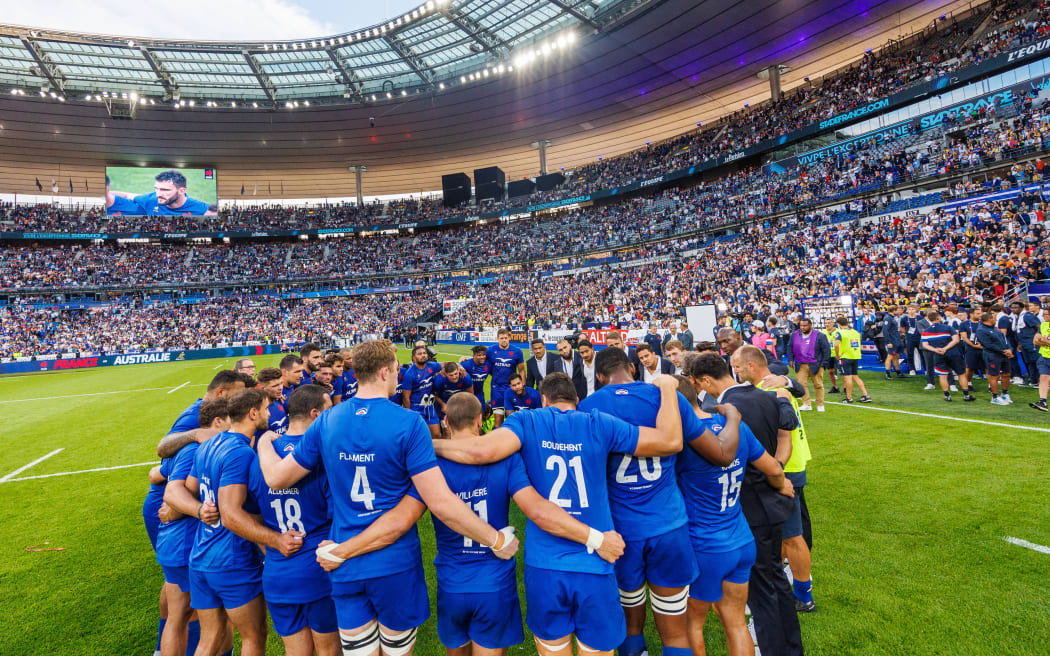 French team in a huddle at the Stade de France.