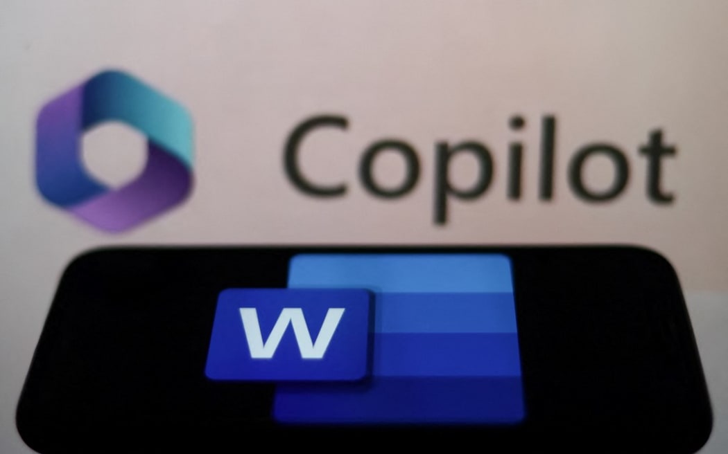 Microsoft Word logo displayed on a phone screen and Copilot displayed on a screen in the background are seen in this illustration photo taken in Krakow, Poland on March 16, 2023. (Photo by Jakub Porzycki/NurPhoto) (Photo by Jakub Porzycki / NurPhoto / NurPhoto via AFP)