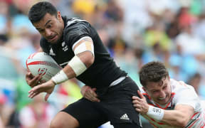 Sherwin Stowers is stopped by an England tackler.