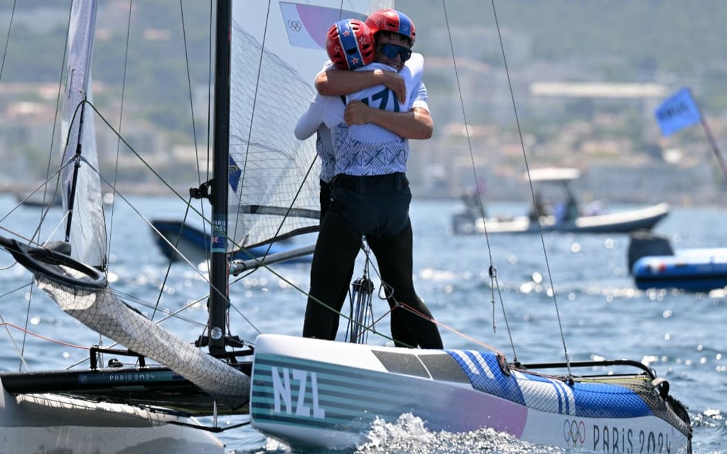 Bronze medallists New Zealand's Micah Wilkinson and Erica Dawson celebrate after the medal race of the mixed Nacra 17 multihull event during the Paris 2024 Olympic Games sailing competition at the Roucas-Blanc Marina in Marseille on August 8, 2024. (Photo by NICOLAS TUCAT / AFP)