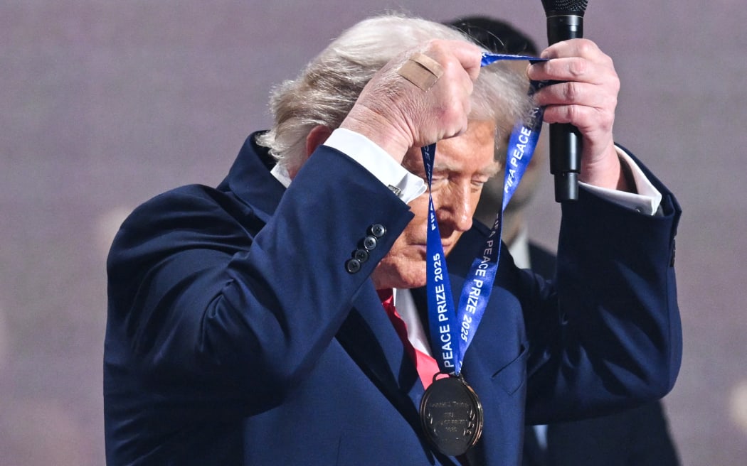 US President Donald Trump receives the FIFA Peace Prize during the draw for the 2026 FIFA Football World Cup taking place in the US, Canada and Mexico, at the Kennedy Center, in Washington, DC, on December 5, 2025. (Photo by SAUL LOEB / AFP)