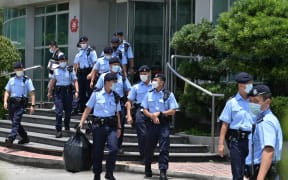 Police officers leave the Apple Daily newspaper offices in Hong Kong on June 17, 2021.
