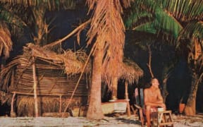 An old photo. Tom sits on the beach in a deck chair on a beautiful desert island.