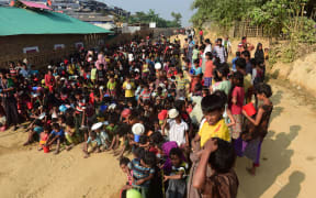 Rohingya refugee children wait for food at a food distribution center in Thankhali refugee camp in the Bangladeshi district of Ukhia.