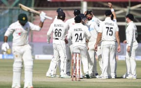 New Zealand's cricketers celebrate after the dismissal of Pakistan's Sarfaraz Ahmed during the fifth and final day of the first Test match in Karachi, 2022.
