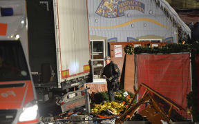 An officer inspects the truck after it crashed into a crowd near a Christmas market in Berlin.
