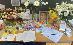Takapuna Grammar School students and teachers decorated Hu’s desk with letters, origami cranes, and flowers as a tribute.
