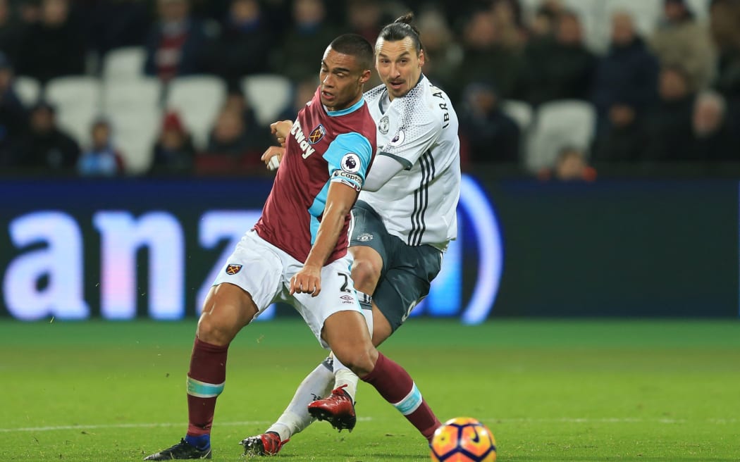Winston Reid and Zlatan Ibrahimovic tussle for the ball.