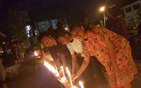 People in Jayapura light candles to show support for the jailed former governor of Jakarta, Ahok.