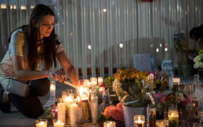 Las Vegas resident Dashenka Giraldo lights candles at a makeshift memorial at the northern end of the Last Vegas Strip.