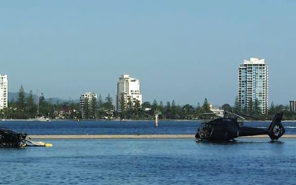 In this handout photo taken and released on January 3, 2023 two helicopters rest in water after colliding in mid-air in Gold Coast on January 2, killing four.