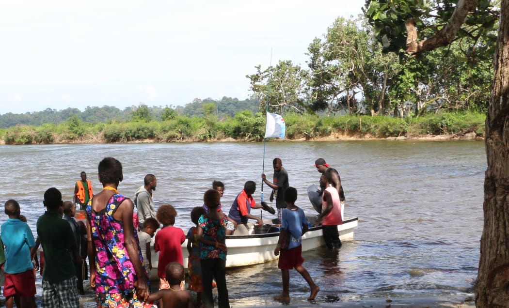 A group of villagers on the Carteret Islands wade into a bay to receive a supply boat.