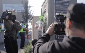 Loafers Lodge resident Chris, last name unknown, lays flowers near the building for his friends he lost in the fire on 16 May, 2023.