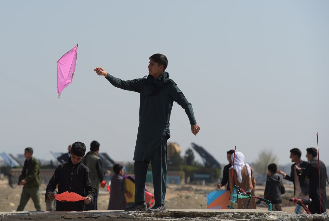 Afghan youths prepare to fly their kites as they celebrate the Nowruz (Noruz), or Persian New Year, in a hilltop overlooking of Kabul on March 21, 2018. / AFP PHOTO / SHAH MARAI