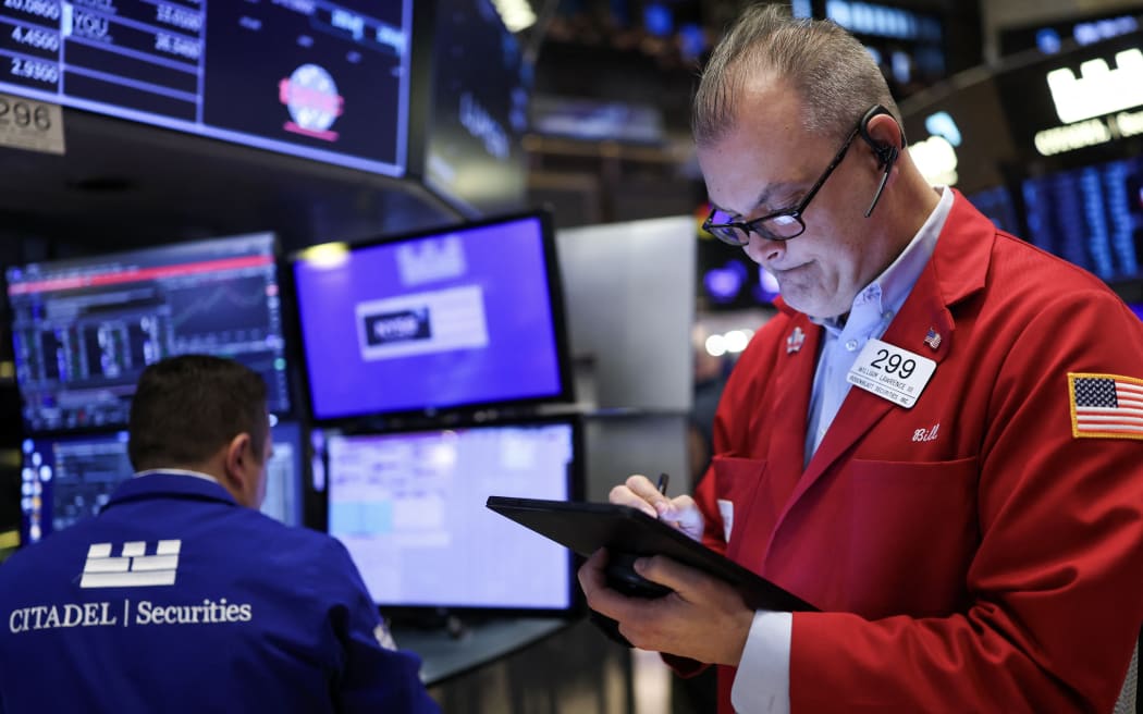 Traders work on the floor of the New York Stock Exchange (NYSE) at the opening bell in New York City, on April 3, 2025. Wall Street stocks sank in early trading on April 3,2025, joining a global equity selloff after President Donald Trump's latest tariff announcement exacerbated worries about a trade war and global economic downturn. (Photo by CHARLY TRIBALLEAU / AFP)