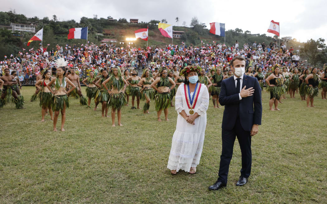 France's President Emmanuel Macron (R) and Hiva Oa Mayor Joëlle Frebault (in white) attend a welcoming ceremony during his visit to Atuona on Hiva Oa, the second largest island of the Marquesas Islands, French Polynesia on July 25, 2021.