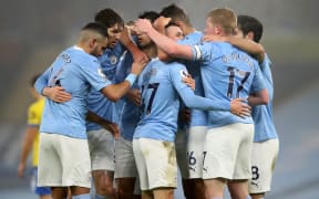 Manchester City's English midfielder Phil Foden (C) celebrates scoring his team's first goal with teammates during the English Premier League football match between Manchester City and Brighton and Hove Albion at the Etihad Stadium in Manchester, north west England, on January 13, 2021.