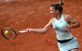 (FILES) In this file photo taken on May 26, 2022 Romania's Simona Halep returns to China's Qinwen Zheng during their women's singles match on day five of the Roland-Garros Open tennis tournament at the Court Simonne-Mathieu in Paris. - Former world number one Simona Halep has been provisionally suspended for doping after testing positive for a banned substance, the International Tennis Integrity Agency (ITIA) said on October 21, 2022. (Photo by Anne-Christine POUJOULAT / AFP)