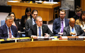 Israeli Ambassador to the UN Gilad Erdan (C) speaks, flanked by UN Relief and Works Agency (UNRWA) Commissioner General Philippe Lazzarini (L) and US Deputy Ambassador to the UN Robert Wood (R), during a United Nations Security Council meeting at UN headquarters in New York on April 17, 2024. (Photo by Charly TRIBALLEAU / AFP)