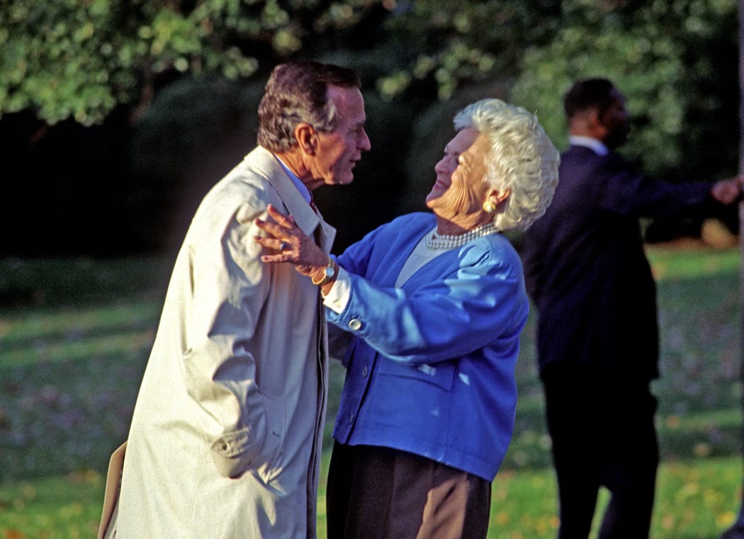 United States President George H.W. Bush hugs first lady Barbara Bush as he departs the South Lawn of the White House in Washington, DC in 1992.