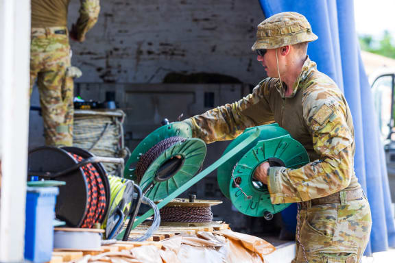 ADF personnel unload a truck containing HESCO fortification barriers during Operation RENDER SAFE, Nauru.