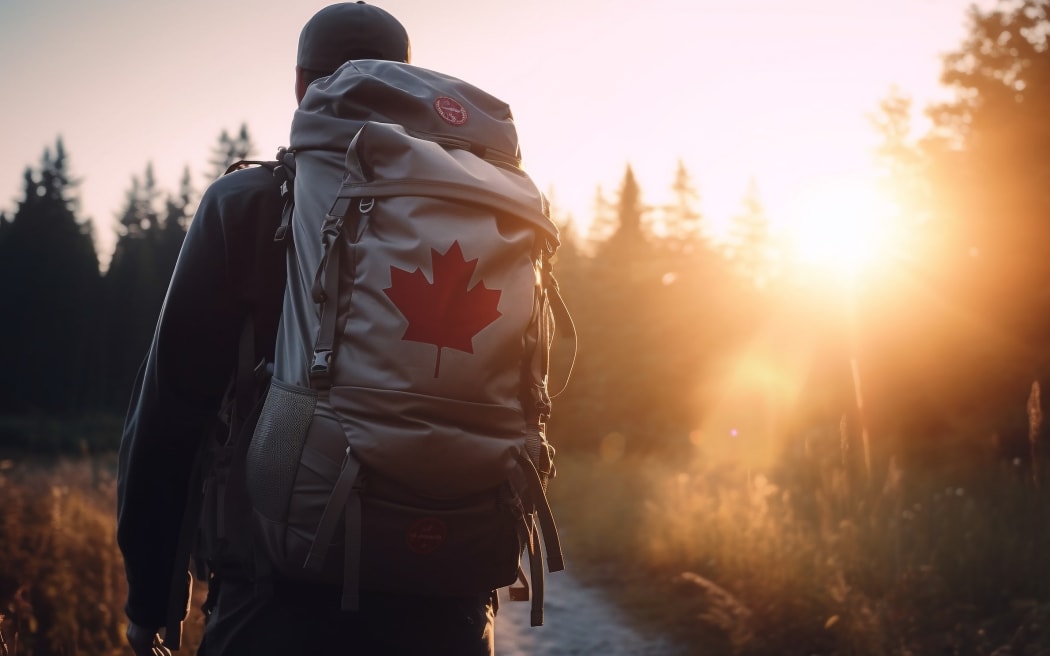 A man with a backpack walks through a forest at golden hour. The sun shines behind him, creating a warm and inviting atmosphere. The image evokes a sense of adventure and exploration.