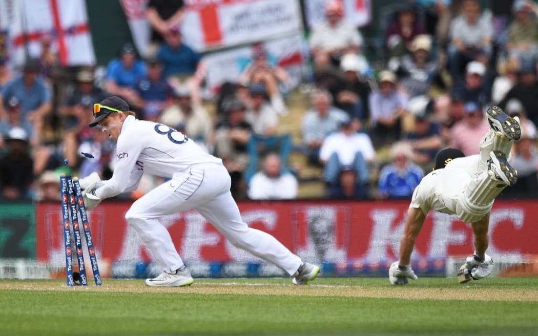 Ollie Pope attempts a run out as Glenn Phillips dives during the first cricket test between New Zealand and England at Hagley Oval in Christchurch, Nov 2024.