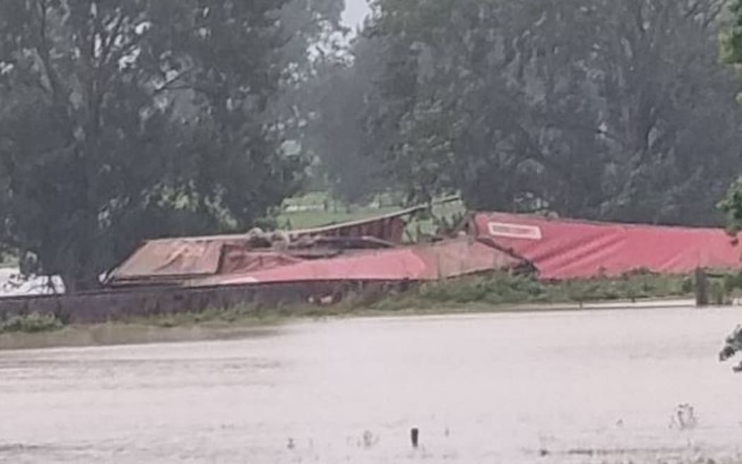 Flood waters surround the derailed train in Te Puke.