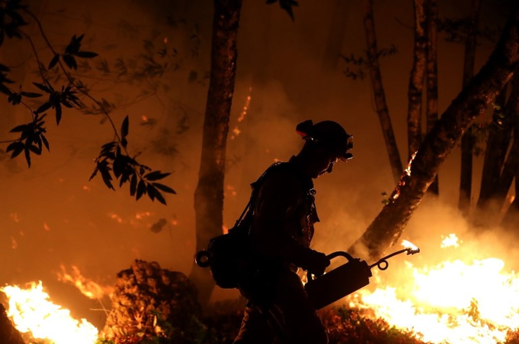 CalFire firefighter Brandon Tolp uses a drip torch during a firing operation near Calistoga, California.