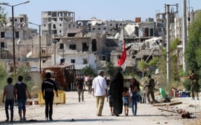 Civilians return to the neighbourhood of Bani Zeid in Aleppo, a day after Syrian government forces took control of the previously rebel-held district.