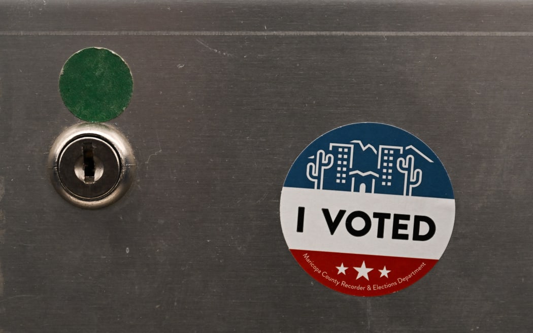 An "I Voted" sticker is displayed on a demonstration ballot lock box at the Maricopa County Tabulation and Election Center (MCTEC) ahead of the 2024 Arizona Primary and General elections in Phoenix, Arizona on June 3, 2024. Maricopa County election workers have repeatedly been the target of harassment and threats since the 2020 US election due to the spread of online misinformation about voter fraud. Officials are preparing for another onslaught of conspiracy theories in the 2024 presidential race by bulking up security and giving public tours at their ballot tabulation facility in downtown Phoenix, Arizona. (Photo by Patrick T. Fallon / AFP)