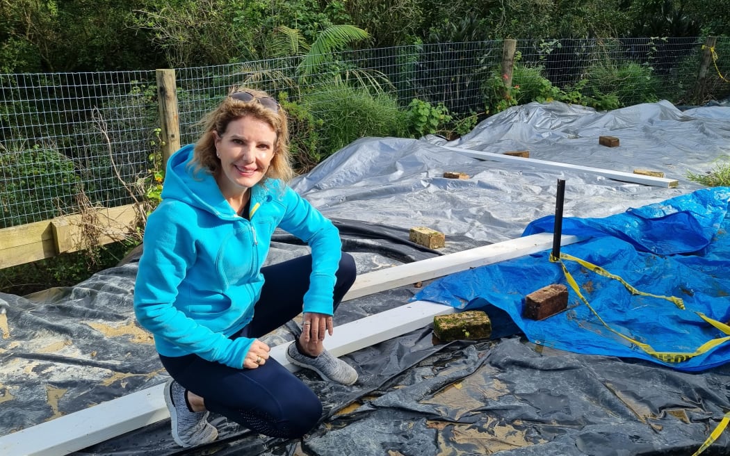 Luci Harrison has spread large tarpaulins over the slip in an attempt to keep water off it and slow its movement.