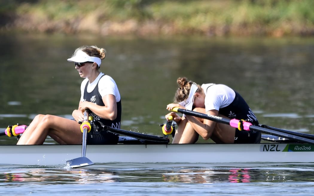 New Zealand's Eve Macfarlane and New Zealand's Zoe Stevenson (L) sit on their boat after the Women's Double Sculls semifinal rowing competition