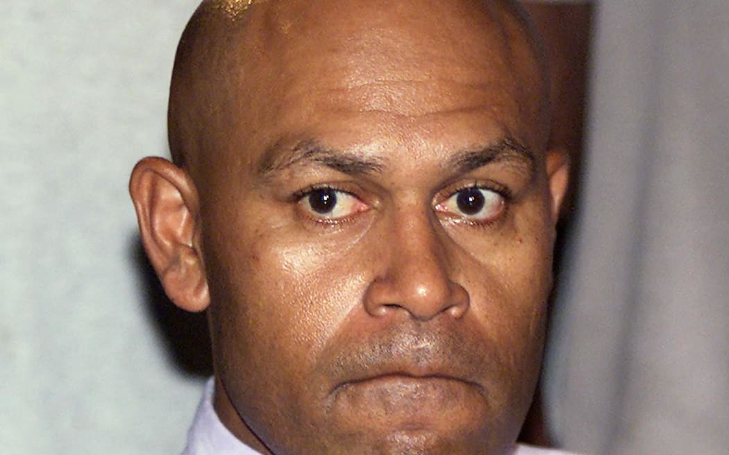 (FILES) This file photo taken June 4, 2000 shows coup plotter George Speight grimacing during a press conference at Parliament House in Suva. Fijian former coup leader George Speight was granted a presidential pardon and freed on September 19, 2024, after spending 24 years in jail on treason charges. (Photo by Torsten BLACKWOOD / AFP)
