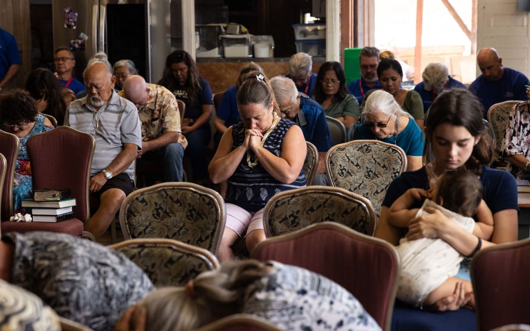 Survivors and churchgoers pray during a church service held by Pastor Brown of Lahaina's Grace Baptist Church, in Wailuku, central Maui.