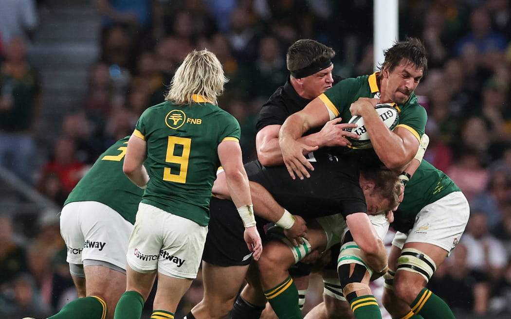 Eben Etzebeth of South Africa is tackled by Scott Barrett of New Zealand.