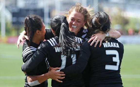 4 women hug on field