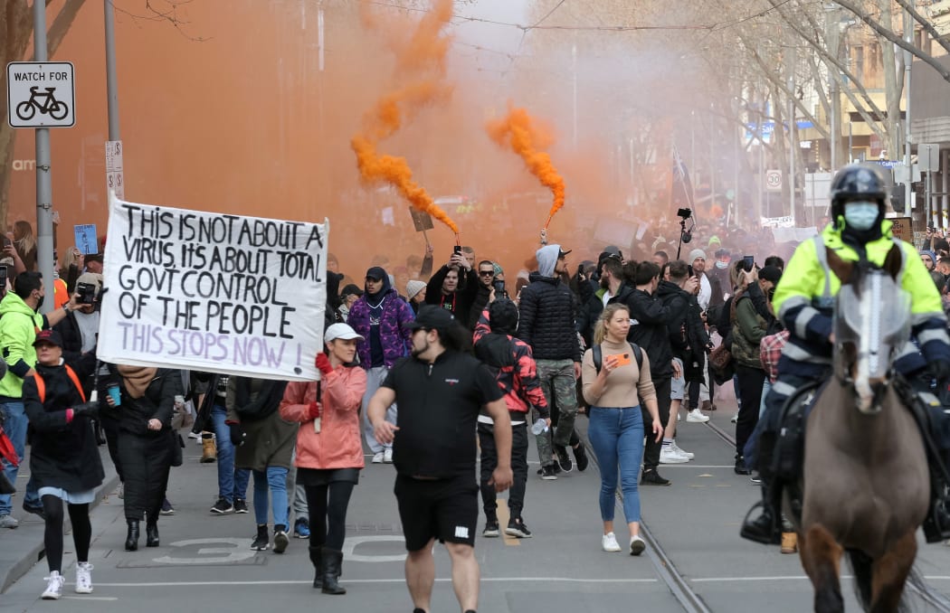 Protesters march down a street during a rally Melbourne on July 24, 2021 to demonstrate against the city's restrictions due to the Covid-19 coronavirus. (Photo by CON CHRONIS / AFP)