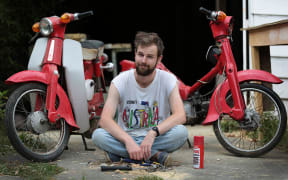 Finn Teppett with his two Honda Cub C50s, neither of which work.