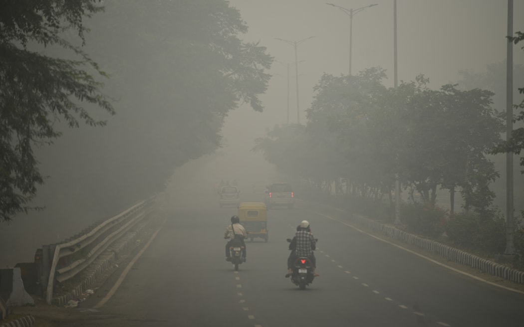 Motorists drive along a road under heavy smog conditions, in New Delhi on 3 November, 2019.
