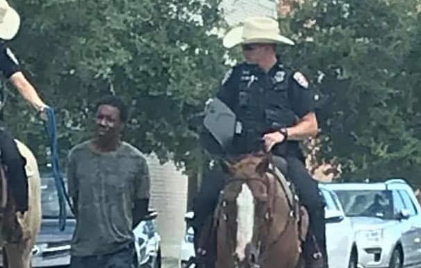 blacTexas police have apologised after an image of two white officers on horseback leading a handcuffed k man by a rope caused an outcry online.
