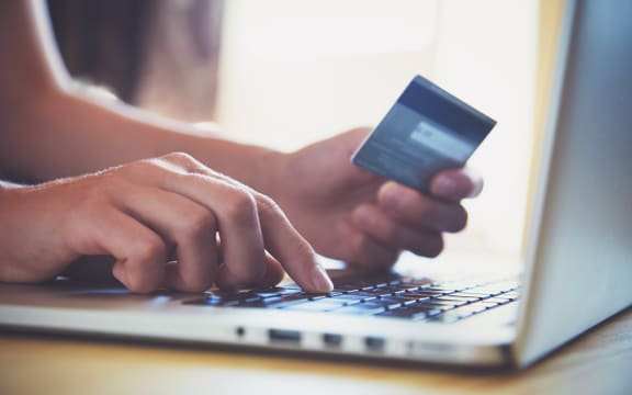 Hands holding credit card and using laptop. Online shopping