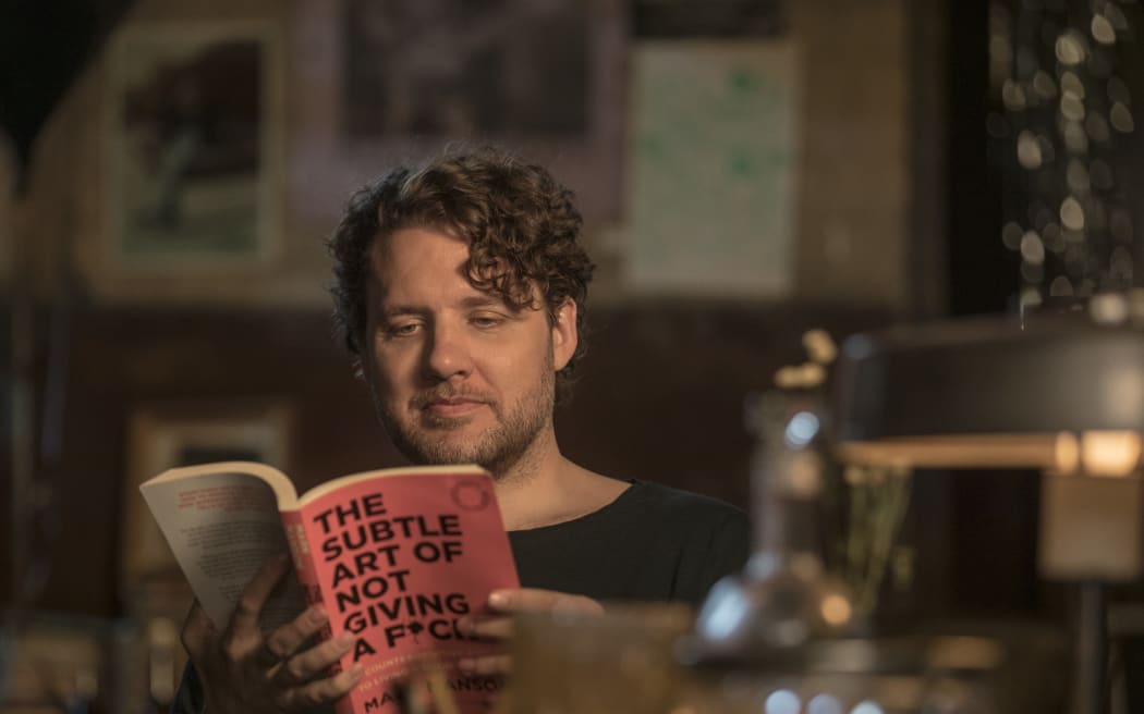 Self Help author Mark Manson with his book The Subtle Art of Not Giving A F**K
