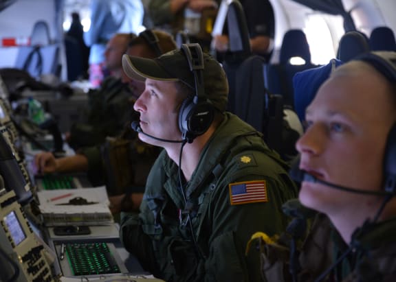 US Navy personnel monitoring search data aboard a P-8A Poseidon over the Indian Ocean.